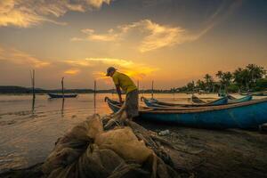 traditionnel les pêcheurs et bateaux dans o prêt lagune pendant coucher de soleil, phu yen province, vietnam. Voyage et paysage concept photo