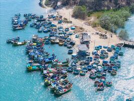 aérien vue de loc un pêche village, vung tau ville. une pêche Port avec tsunami protection béton blocs. paysage urbain et traditionnel bateaux dans le mer. photo