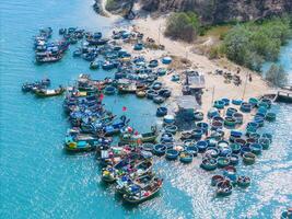 aérien vue de loc un pêche village, vung tau ville. une pêche Port avec tsunami protection béton blocs. paysage urbain et traditionnel bateaux dans le mer. photo