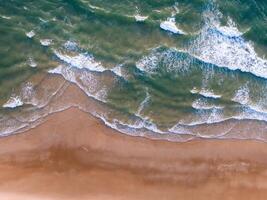 océan vagues sur le plage comme une Contexte. aérien Haut vers le bas vue de plage et mer avec bleu l'eau vagues. vietnam plage photo