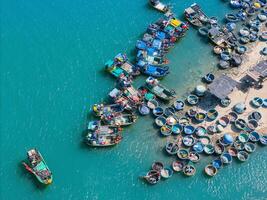 aérien vue de loc un pêche village, vung tau ville. une pêche Port avec tsunami protection béton blocs. paysage urbain et traditionnel bateaux dans le mer. photo