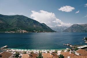 privé sablonneux plage avec Soleil chaises longues sur le front de mer dans de face de le hôtels. huma kotor baie Hôtel et villas. dobrota, Monténégro photo