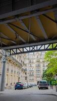 Urbain scène vu de en dessous de une acier pont, mettant en valeur le architectural élégance de Parisien bâtiments sur une assombri jour, idéal pour Voyage et culturel thèmes 15 avril 2024, Paris, France photo