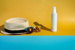 Vide crème solaire bouteille Soleil chapeau et des lunettes de soleil sur minimaliste plage photo