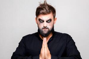 effrayant style mort-vivant maquillage pour Halloween sur une barbu homme qui spectacles gestes photo