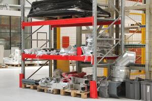 voiture les pièces sur le racks dans le entrepôt. aluminium détails sur étagères de usine. Nouveau métal les pièces photo