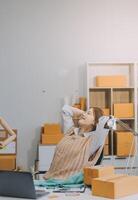 propriétaires de petit en ligne achats prise une Pause avec sa mains derrière sa tête et séance sur une chaise dans sa atelier, se détendre concept photo