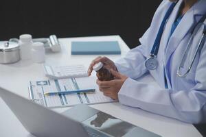 tondu vue de médecin dans blanc manteau en portant bouteille médicament, prescrire pilules à malade patient via en ligne consultation. famille thérapeute recommander qualité médicaments. soins de santé, traitement concept photo