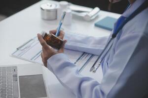 tondu vue de médecin dans blanc manteau en portant bouteille médicament, prescrire pilules à malade patient via en ligne consultation. famille thérapeute recommander qualité médicaments. soins de santé, traitement concept photo