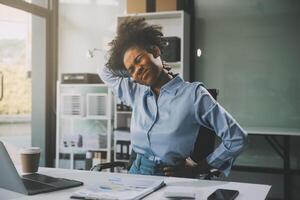 asiatique femme travail difficile dans le Bureau ayant douleurs et des douleurs dans sa torse et taille photo