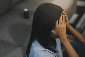 dérangé femme frustré par problème avec travail ou des relations, séance sur canapé, embrassement genoux, couvert visage dans main, sentiment désespoir et anxiété, solitude, ayant psychologique difficulté photo