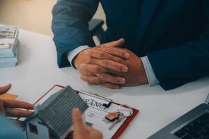 L'agent immobilier a parlé des termes du contrat d'achat de maison et a demandé au client de signer les documents pour conclure le contrat légalement, les ventes de maisons et le concept d'assurance habitation. photo