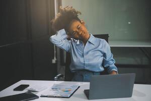 asiatique femme travail difficile dans le Bureau ayant douleurs et des douleurs dans sa torse et taille photo