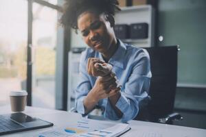 asiatique femme travail difficile dans le Bureau ayant douleurs et des douleurs dans sa torse et taille photo