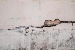 mur de béton fissuré mur cassé au coin de ciment extérieur qui a été affecté par un tremblement de terre et un sol effondré photo