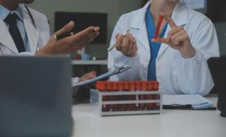 équipe de médical Personnel ayant Matin réunion dans salle de réunion. médecins et infirmières à la recherche à numérique tablette. photo