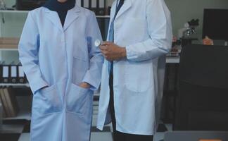 équipe de médical Personnel ayant Matin réunion dans salle de réunion. médecins et infirmières à la recherche à numérique tablette. photo