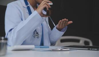 tondu vue de médecin dans blanc manteau en portant bouteille médicament, prescrire pilules à malade patient via en ligne consultation. famille thérapeute recommander qualité médicaments. soins de santé, traitement concept photo