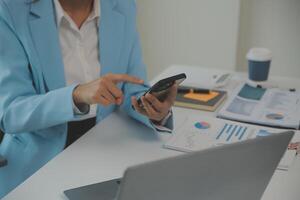 portrait de une content asiatique femme d'affaires en utilisant mobile téléphone intérieur, asiatique femme d'affaires travail dans moderne bureau. photo