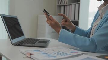 portrait de une content asiatique femme d'affaires en utilisant mobile téléphone intérieur, asiatique femme d'affaires travail dans moderne bureau. photo