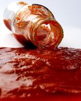 tomate sauce . verre bouteille avec ketchup. ketchup est verser en dehors de le cou de une verre bouteille. photo