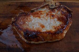 rôti porc entrecôte sur une en bois Coupe planche. grillé porc entrecôte. porc steak. photo