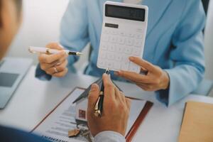 L'agent immobilier a parlé des termes du contrat d'achat de maison et a demandé au client de signer les documents pour conclure le contrat légalement, les ventes de maisons et le concept d'assurance habitation. photo