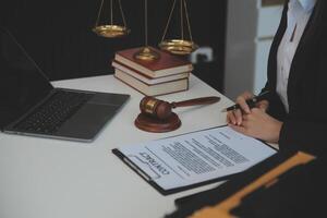 américain femme avocat ou femme d'affaires africain travail avec ordinateur portable, recherche, en cours d'analyse données, en train de lire Contrat les documents travail avec loi livres marteau de Justice consultant avocat concept. photo