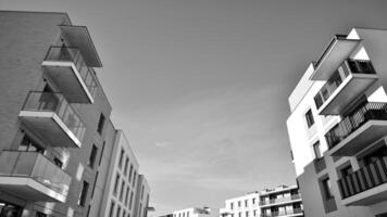 fragment de le bâtiments façade avec les fenêtres et balcons. moderne appartement bâtiments sur une ensoleillé journée. façade de une moderne Résidentiel bâtiment. noir et blanche. photo