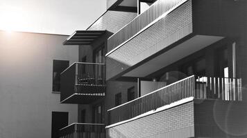 fragment de le bâtiments façade avec les fenêtres et balcons. moderne appartement bâtiments sur une ensoleillé journée. façade de une moderne Résidentiel bâtiment. noir et blanche. photo