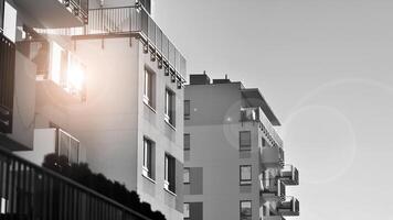 fragment de le bâtiments façade avec les fenêtres et balcons. moderne appartement bâtiments sur une ensoleillé journée. façade de une moderne Résidentiel bâtiment. noir et blanche. photo