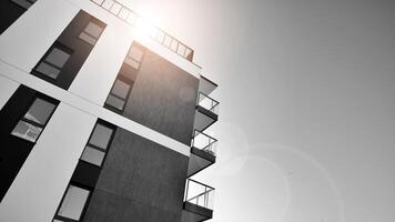 fragment de le bâtiments façade avec les fenêtres et balcons. moderne appartement bâtiments sur une ensoleillé journée. façade de une moderne Résidentiel bâtiment. noir et blanche. photo