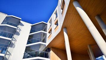 une appartement bâtiment avec une unique architectural solution. une moderne Résidentiel bâtiment avec une blanc façade et permanent sur haute béton piliers. photo