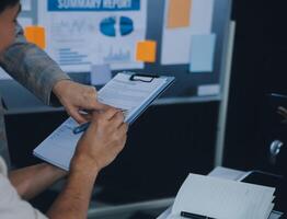 réunion du directeur financier discutant des statistiques financières sur le succès du projet de croissance de l'entreprise, investisseur professionnel travaillant sur un projet de démarrage pour un plan stratégique avec document, ordinateur portable et tablette numérique. photo