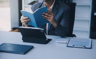 coup de un attrayant mature femme d'affaires travail sur portable dans sa poste de travail. photo