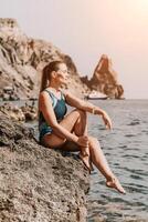 femme Voyage été mer. une content touristique dans une bleu bikini profiter le scénique vue de le mer et volcanique montagnes tandis que prise des photos à Capturer le souvenirs de sa Voyage aventure.