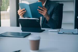 coup de un attrayant mature femme d'affaires travail sur portable dans sa poste de travail. photo