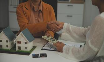 discussion avec un agent immobilier, modèle de maison avec agent et client discutant du contrat d'achat, d'assurance ou de prêt immobilier ou immobilier. photo