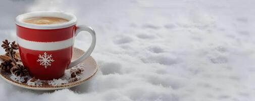 une tasse de chaud cappuchino café sur neige.noël café. photo