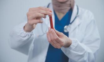 technicien, médecin, scientifique dans laboratoire avec du sang échantillon tubes et grille dans le laboratoire en portant une du sang navire échantillon pour étude, expérience, médical recherche biotechnologie ADN essai. photo