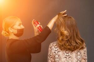 femmes salon coiffure. coiffeur les usages Laque pour les cheveux sur du client cheveux dans salon, portrait de deux magnifique femmes photo