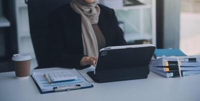 coup de un attrayant mature femme d'affaires travail sur portable dans sa poste de travail. photo