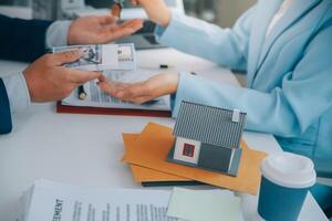 L'agent immobilier a parlé des termes du contrat d'achat de maison et a demandé au client de signer les documents pour conclure le contrat légalement, les ventes de maisons et le concept d'assurance habitation. photo