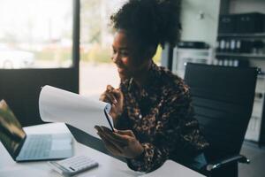 femme d'affaires en utilisant calculatrices pour faire math la finance sur en bois bureaux dans Bureau et affaires travail arrière-plan, impôt, comptabilité, statistiques, et analytique recherche concept photo