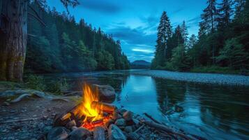 paisible au bord de la rivière site de camp illuminé par le vacillant lumière de feu de camp photo