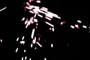 un cierge magique rouge lite abstrait recouvre une texture élégante flou étincelant sur le noir. photo