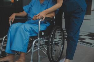 médecin donnant espoir. proche en haut coup de Jeune femelle médecin penché vers l'avant à souriant personnes âgées Dame patient en portant sa main dans palmiers. femme le concierge dans blanc manteau justificatif encourageant vieux la personne photo