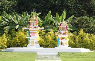 traditionnel thaïlandais esprit Maisons avec vert jardin Contexte. photo