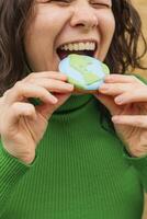 Terre journée concept. femme mord dans une biscuit dans le forme de le Terre. photo