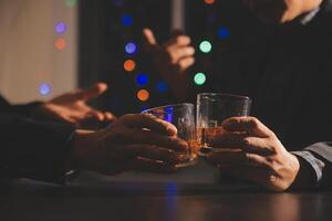 fête nuit, verser whisky dans une verre. donner à copains qui viens à célébrer photo